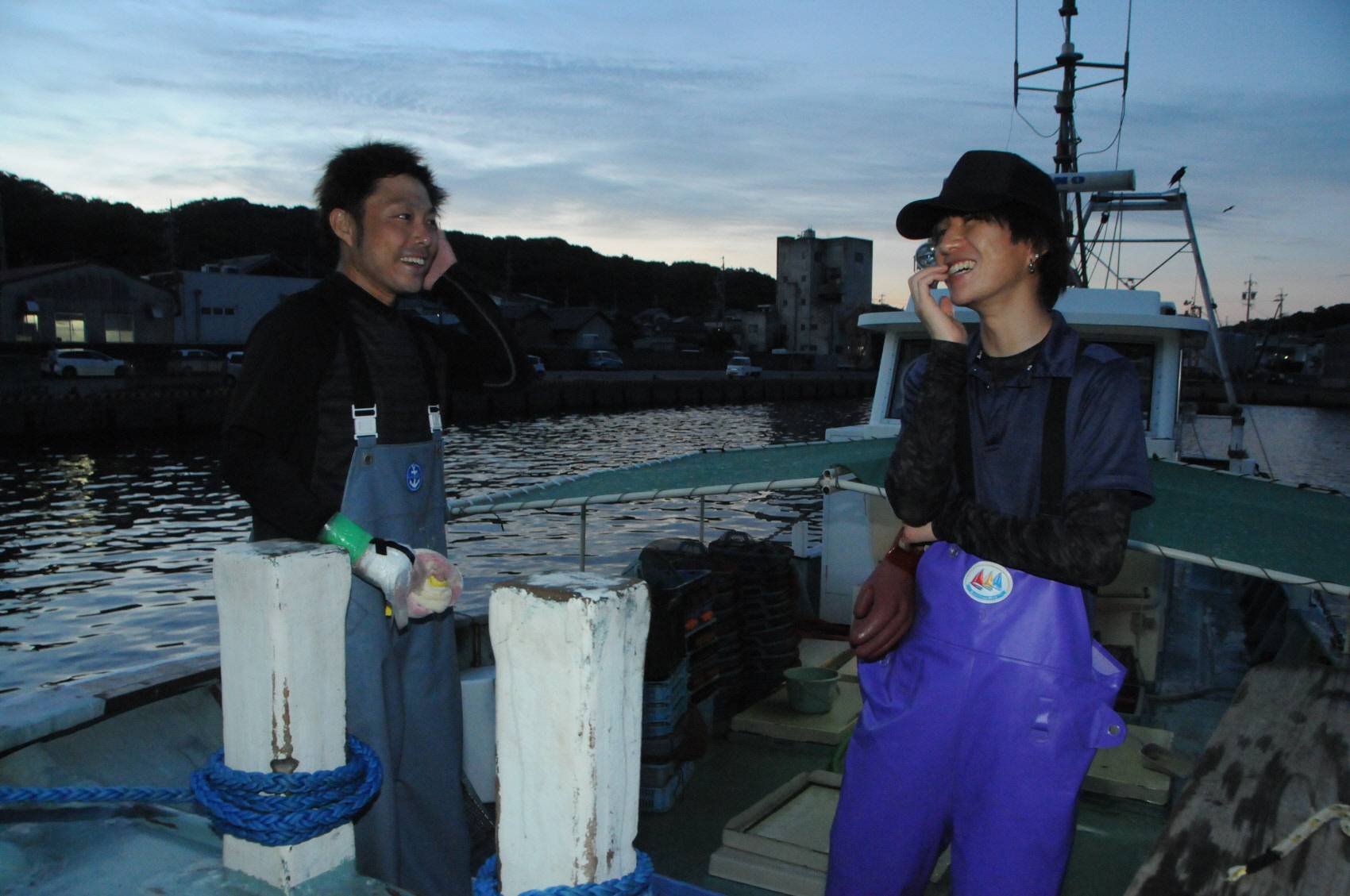 Genta Okasaka (à direita) fala com o pescador Keita Urata no porto de Chigara em Gamagori, província de Aichi. | CHUNICHI SHIMBUN